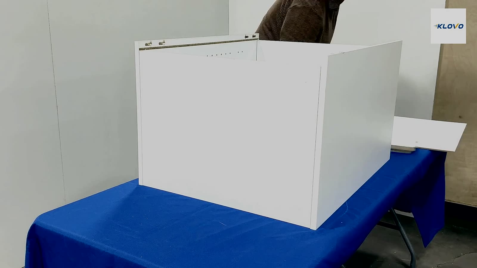 A Klovo cabinet box being assembled by hand — panels pressed together with patent-pending GlideLock